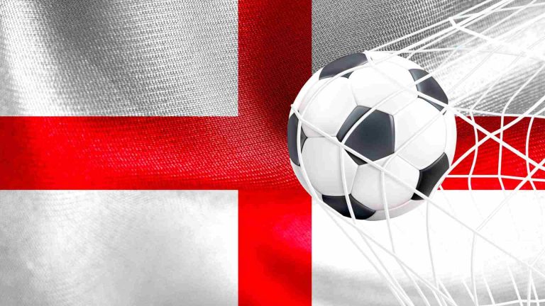 Bandeira da Inglaterra com bola no gol Governo da Inglaterra abre consulta para banir publicidade de apostas no esporte após mostrar preocupações com corretoras de criptomoedas