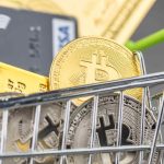 Carrinho com bitcoin, ouro e cartão em destaque