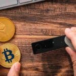 Carteira com bitcoin e ethereum próximo de computadores