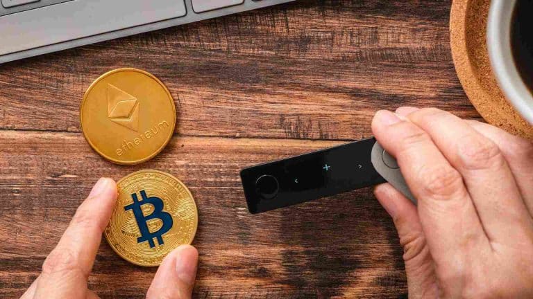 Carteira com bitcoin e ethereum próximo de computadores
