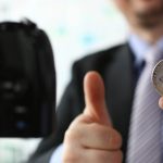 Homem segurando bitcoin em live BTG Pactual, Itaú e Bradesco se unem a Banco Central para discutir regulação em evento da ANBIMA