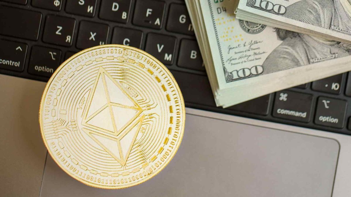 Ethereum com notas de Dólar próximo de computador Criptomoeda dispara 100% em 20 minutos e hacker leva R$ 30 milhões em roubo que teve pausa de blockchain e reversão de blocos