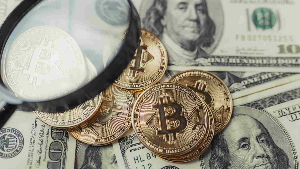 Lupa com destaque em bitcoins e dólares Empresa de rastreio de criptomoedas passa a valer US$ 2 bilhões após nova captação de recursos