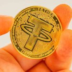 Mão segurando USDT Tether