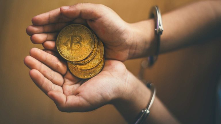 Pessoa presa com algema e mãos com bitcoins "A carteira está lá com a fortuna, mas não sei a senha de cabeça", diz Faraó dos bitcoins