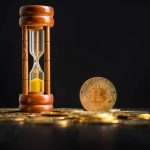 Bitcoin ao lado de ampulheta de tempo