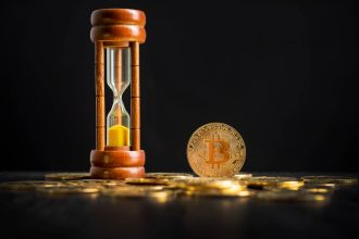 Bitcoin ao lado de ampulheta de tempo