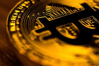 Bitcoin dourado com escrita em preto
