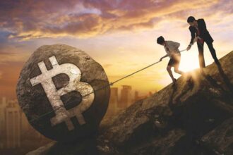 Homem e mulher tentando segurar pedra de bitcoin em montanha Ripio, Mercado Bitcoin e outras corretoras pedem registro no Banco Central antes do prazo final no dia 30 de outubro
