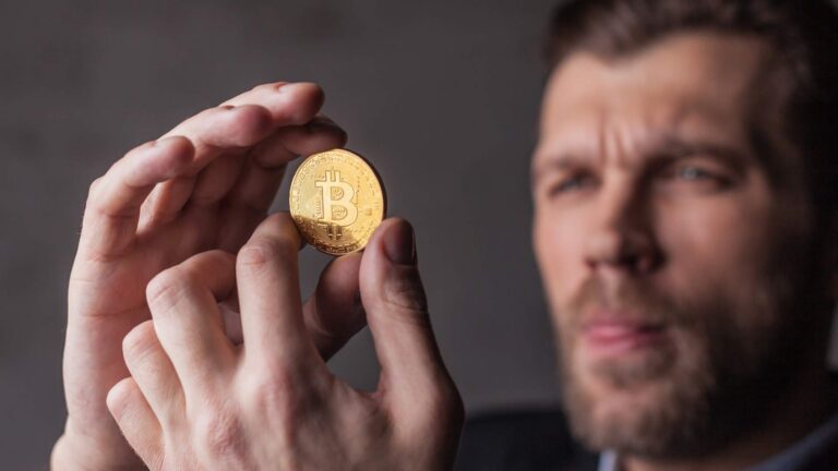 Homem segurando bitcoin com análise Prazo do Banco Central para corretoras de criptomoedas vence na sexta-feira (30), mas dia 6 de novembro preocupa especialista