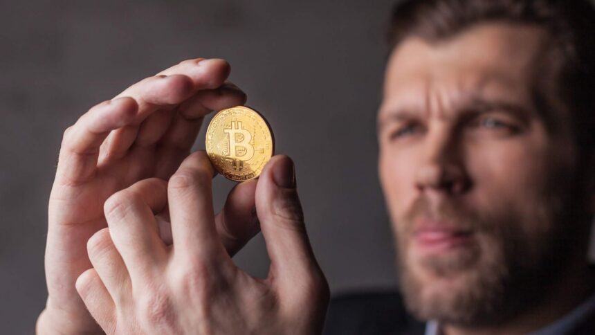 Homem segurando bitcoin com análise Prazo do Banco Central para corretoras de criptomoedas vence na sexta-feira (30), mas dia 6 de novembro preocupa especialista