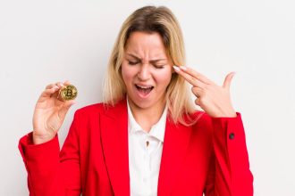 Mulher com bitcoin simbólico na mão e desesperada Contadora é acusada de inventar prejuízos com criptomoedas para fraudar imposto de renda nos EUA