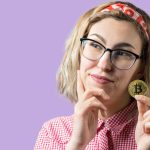 Mulher segurando bitcoin na mão com dúvidas Justiça manda Nubank revelar todas as transações de criptomoedas em conta de cliente após julgado à revelia