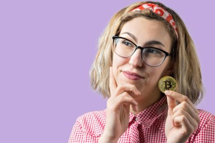 Mulher segurando bitcoin na mão com dúvidas Justiça manda Nubank revelar todas as transações de criptomoedas em conta de cliente após julgado à revelia