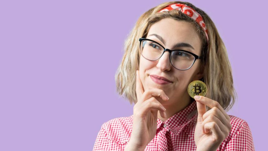 Mulher segurando bitcoin na mão com dúvidas Justiça manda Nubank revelar todas as transações de criptomoedas em conta de cliente após julgado à revelia