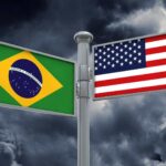 Placas de orientação com bandeira do Brasil e dos EUA Após a eleição no Brasil, procura por orientação migratória para os Estados Unidos aumenta 30 vezes