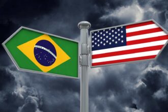 Placas de orientação com bandeira do Brasil e dos EUA Após a eleição no Brasil, procura por orientação migratória para os Estados Unidos aumenta 30 vezes