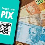 Sistema de pagamento digital do Brasil, o Pix, ao lado de notas do Real brasileiro