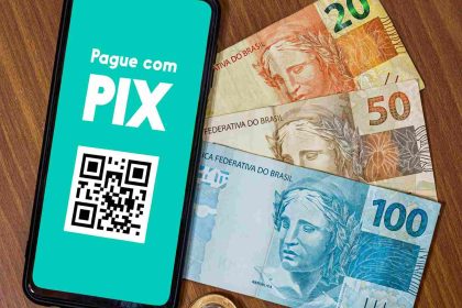 Sistema de pagamento digital do Brasil, o Pix, ao lado de notas do Real brasileiro