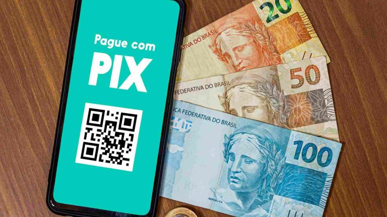 Sistema de pagamento digital do Brasil, o Pix, ao lado de notas do Real brasileiro